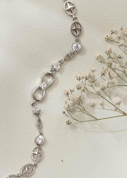 Silver bracelet with diamond accents on a light background with small flowers