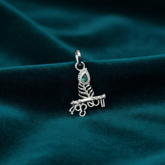 Silver-pendant-with-green-gemstone-on-a-teal-fabric background