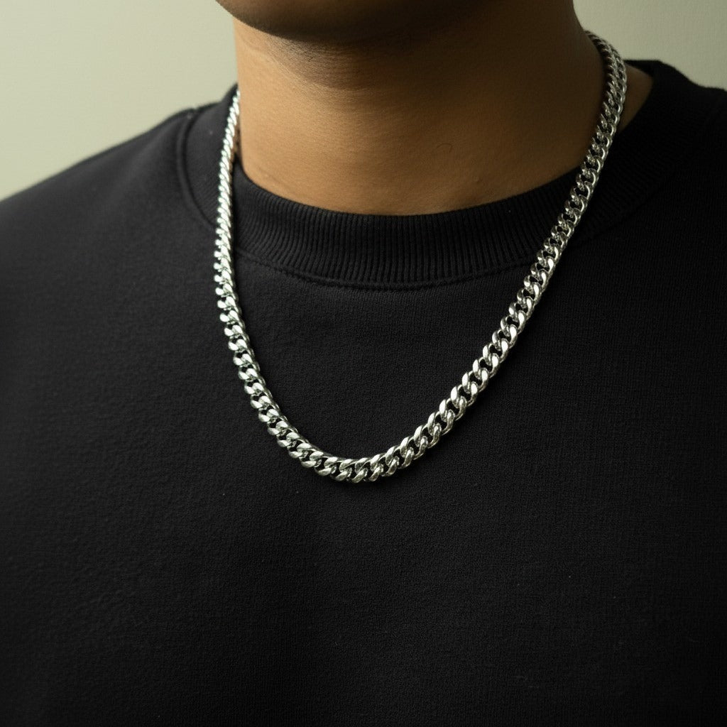Person-wearing-a-silver-chain-necklace-against-a-neutral-background